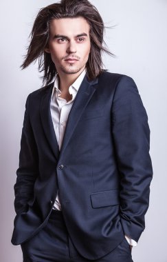 zarif genç yakışıklı uzun saçlı adam kostüm. Studio moda portre.