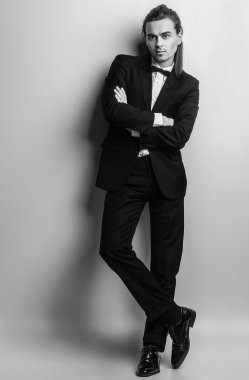 zarif genç yakışıklı uzun saçlı adam kostüm. Studio moda portre.