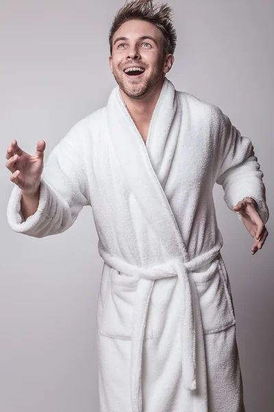 Handsome smiling young man in luxurious bathrobe. — Stock Photo, Image