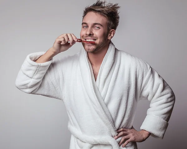 Handsome smiling young man in luxurious bathrobe. — Stock Photo, Image