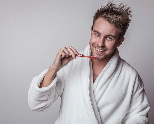 Bonito jovem sorridente em roupão de banho luxuoso . — Fotografia de Stock