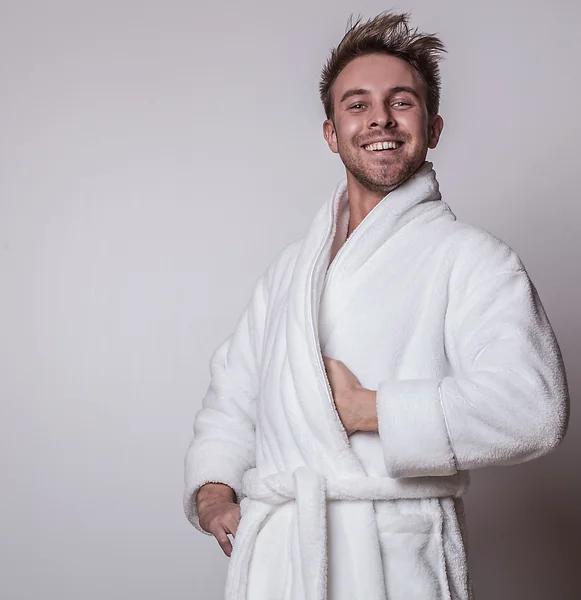 Stilig leende ung man i lyxig badrock. — Stockfoto