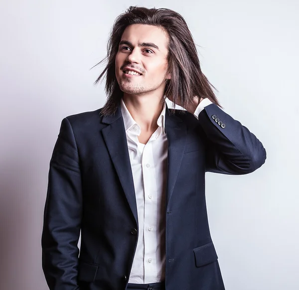 Elegante joven guapo hombre de pelo largo en traje. Estudio retrato de moda . — Foto de Stock