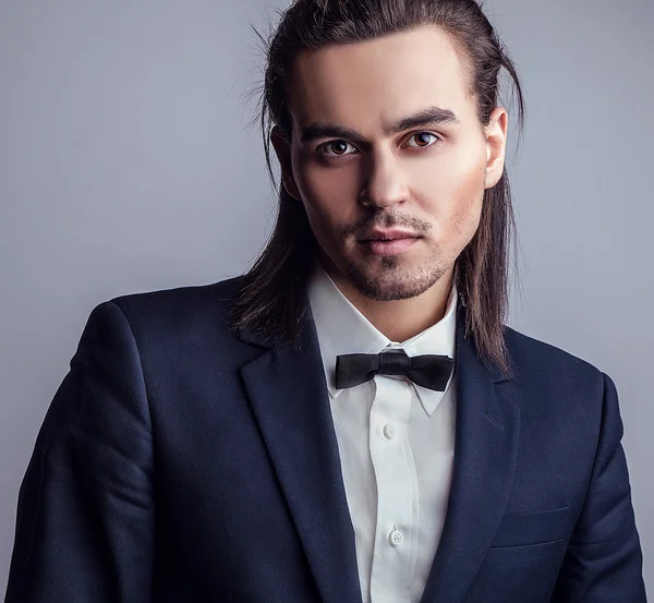 Elégant jeune homme aux cheveux longs en costume. Studio portrait de mode . — Photo