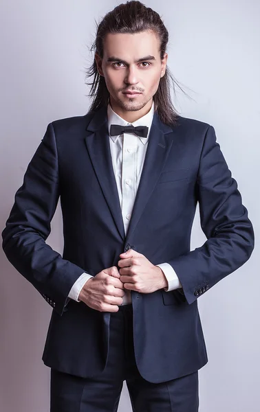 Elégant jeune homme aux cheveux longs en costume. Studio portrait de mode . — Photo