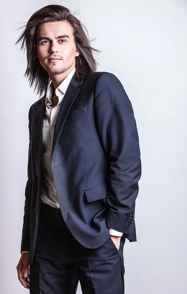Elegant ung vacker långhårig man i kostym. Studio mode porträtt. — Stockfoto
