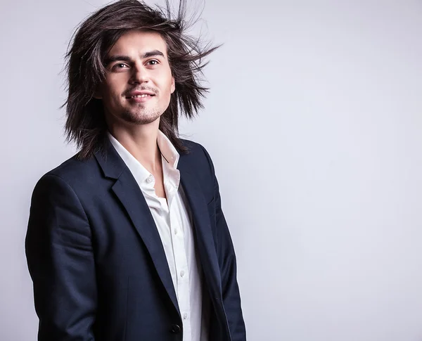 Elégant jeune homme aux cheveux longs en costume. Studio portrait de mode . — Photo