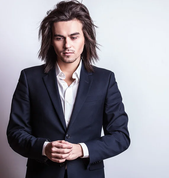 Elegante joven guapo hombre de pelo largo en traje. Estudio retrato de moda . — Foto de Stock