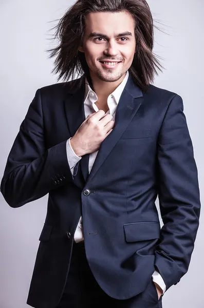 Elegant young handsome long-haired man in costume. Studio fashion portrait. — Stock Photo, Image