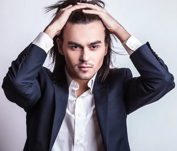 Elégant jeune homme aux cheveux longs en costume. Studio portrait de mode . — Photo