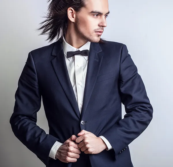 Elegante giovane uomo dai capelli lunghi in costume. Studio ritratto di moda . — Foto Stock