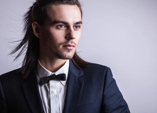 Elegante joven guapo hombre de pelo largo en traje. Estudio retrato de moda . — Foto de Stock