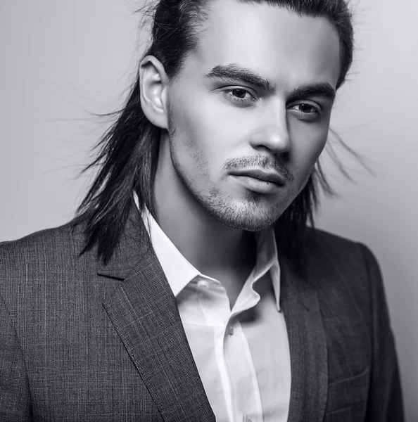 Elegante joven guapo hombre de pelo largo en traje. Estudio retrato de moda . — Foto de Stock