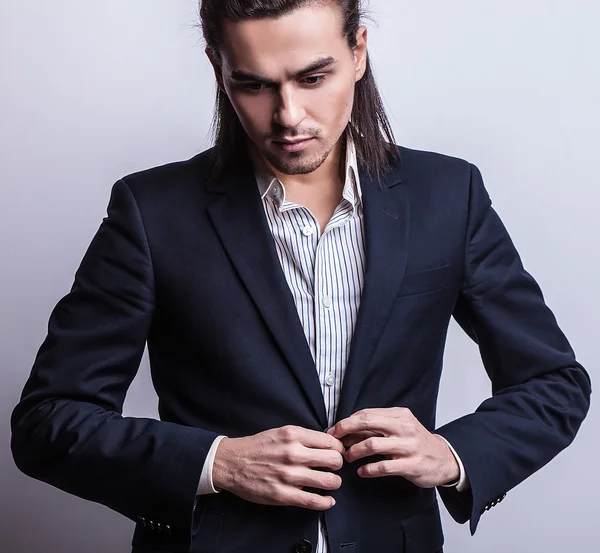 Elegante joven guapo hombre de pelo largo en traje. Estudio retrato de moda . — Foto de Stock