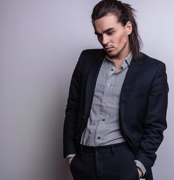 Elegante joven guapo hombre de pelo largo en traje. Estudio retrato de moda . —  Fotos de Stock