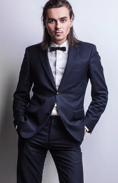 Elegancki młody przystojny długowłosy mężczyzna w stroju. Studio moda piękny portret. — Zdjęcie stockowe