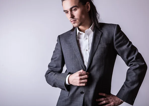 Elegante jonge knappe langharige man in kostuum. Studio mode portret. — Stockfoto