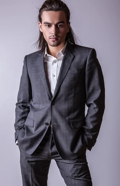 Elegante joven guapo hombre de pelo largo en traje. Estudio retrato de moda . — Foto de Stock