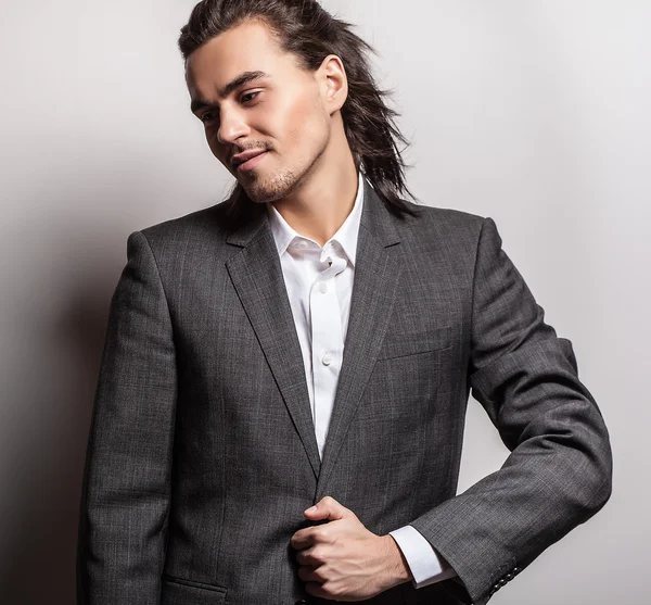 Elegant young handsome long-haired man in costume. Studio fashion portrait. — Stock Photo, Image
