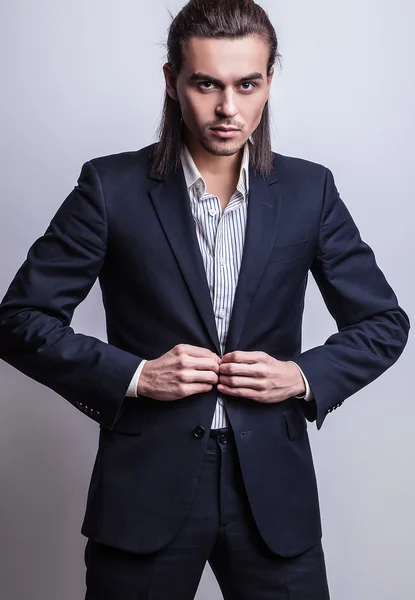 Elégant jeune homme aux cheveux longs en costume. Studio portrait de mode . — Photo