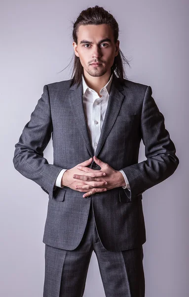 Elegant ung vacker långhårig man i kostym. Studio mode porträtt. — Stockfoto