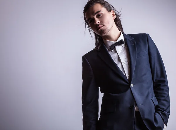 Elegant young handsome long-haired man in costume. Studio fashion portrait. — Stock Photo, Image