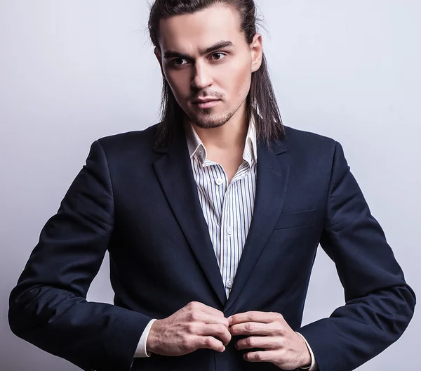 Elegant young handsome long-haired man in costume. Studio fashion portrait. — Stock Photo, Image