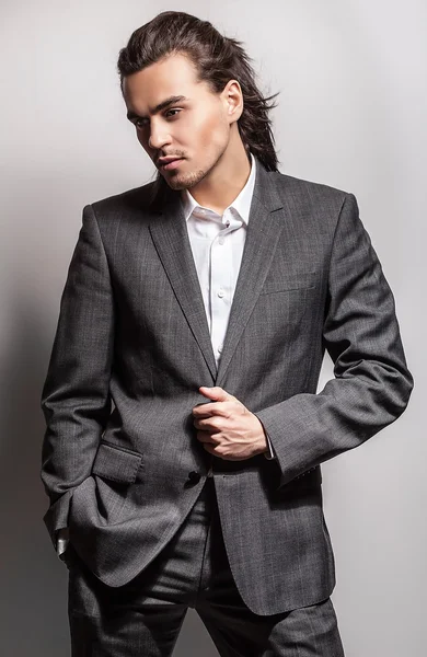 Elégant jeune homme aux cheveux longs en costume. Studio portrait de mode . — Photo