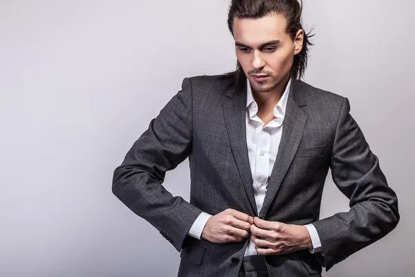 Elegante joven guapo hombre de pelo largo en traje. Estudio retrato de moda . — Foto de Stock