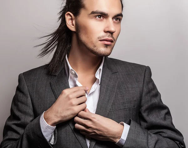 Elegancki młody przystojny długowłosy mężczyzna w stroju. Studio moda piękny portret. — Zdjęcie stockowe