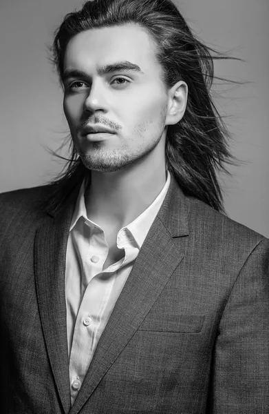Elegáns szép hosszú hajú fiatalember jelmez. Stúdió divat-portré. — Stock Fotó