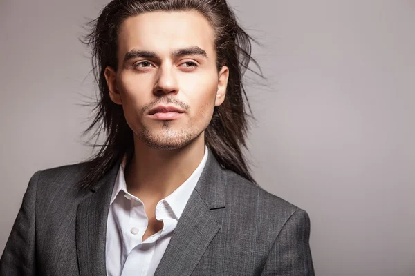 Elegant young handsome long-haired man in costume. Studio fashion portrait. — Stock Photo, Image