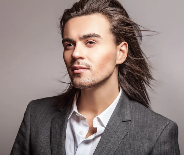 Elegante joven guapo hombre de pelo largo en traje. Estudio retrato de moda . — Foto de Stock