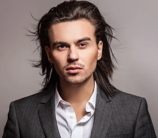 Elégant jeune homme aux cheveux longs en costume. Studio portrait de mode . — Photo