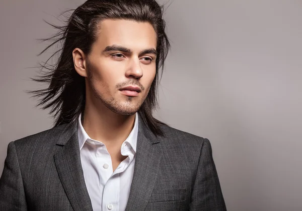 Elegante joven guapo hombre de pelo largo en traje. Estudio retrato de moda . —  Fotos de Stock