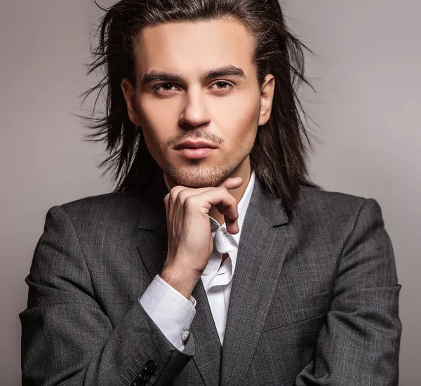 Elégant jeune homme aux cheveux longs en costume. Studio portrait de mode . — Photo