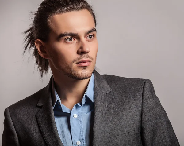 Elegante joven guapo hombre de pelo largo en traje. Estudio retrato de moda . — Foto de Stock