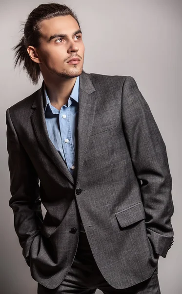 Elégant jeune homme aux cheveux longs en costume. Studio portrait de mode . — Photo