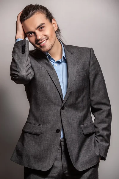 Elegante joven guapo hombre de pelo largo en traje. Estudio retrato de moda . — Foto de Stock