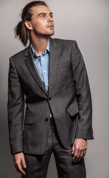 Elegante joven guapo hombre de pelo largo en traje. Estudio retrato de moda . — Foto de Stock