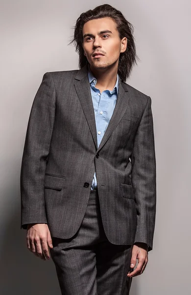 Elegant young handsome long-haired man in costume. Studio fashion portrait. — Stock Photo, Image