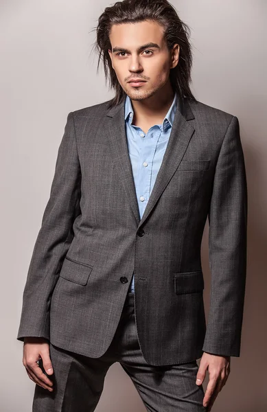 Elegante joven guapo hombre de pelo largo en traje. Estudio retrato de moda . — Foto de Stock