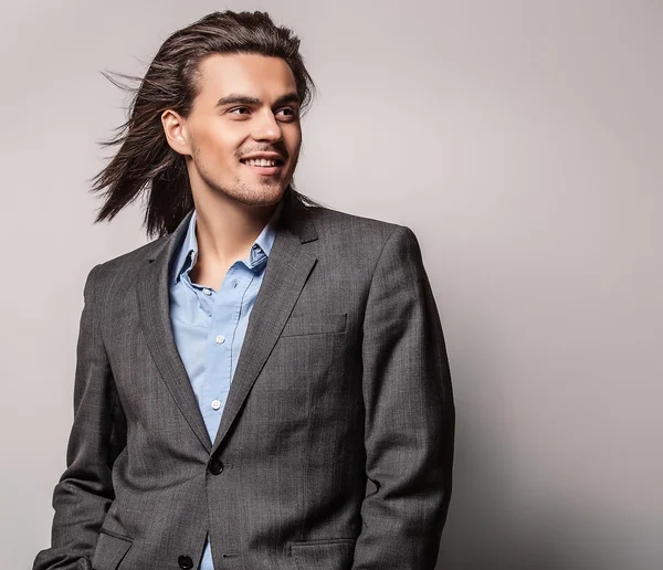 Elegant young handsome long-haired man in costume. Studio fashion portrait. — Stock Photo, Image