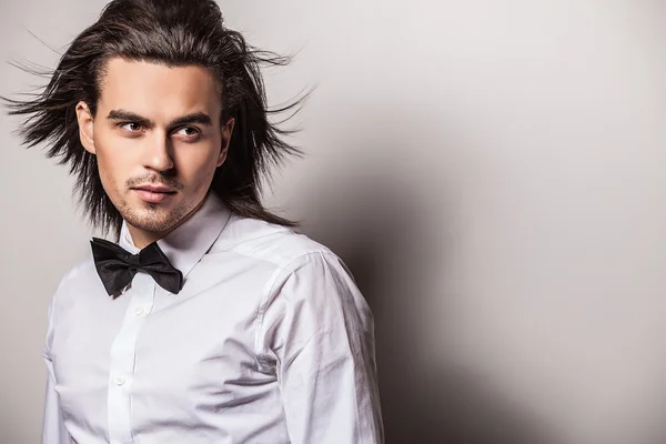 Elegant young handsome long-haired man in costume. Studio fashion portrait. — Stock Photo, Image