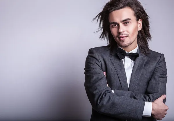 Elégant jeune homme aux cheveux longs en costume. Studio portrait de mode . — Photo