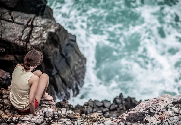 Красива молода жінка сидить на скелі — стокове фото