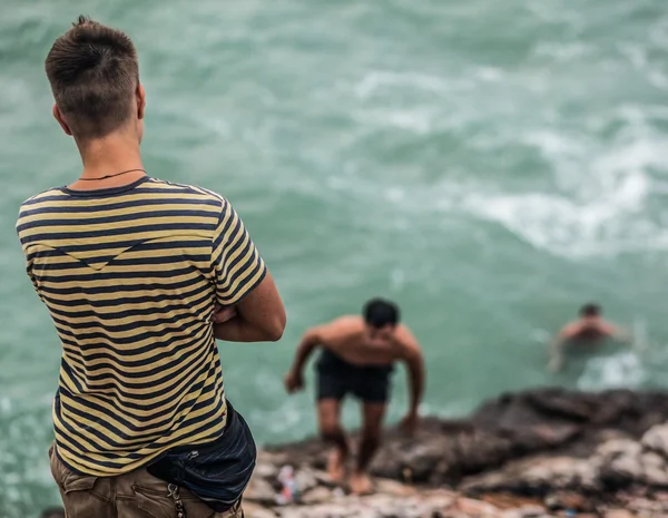 Jovem nas rochas junto ao mar — Fotografia de Stock