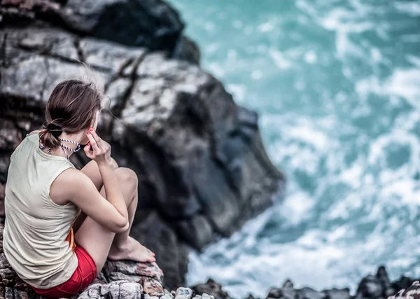 Hermosa joven sentada en la roca — Foto de Stock