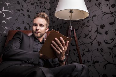 yakışıklı delikanlı lüks kanepede rahatlatıcı koyu elbiseli.