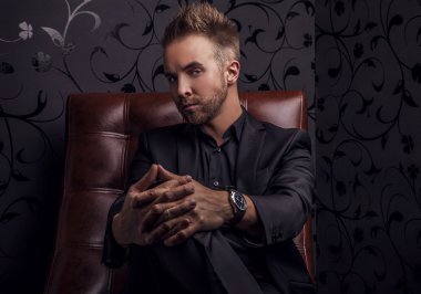 yakışıklı delikanlı lüks kanepede rahatlatıcı koyu elbiseli.